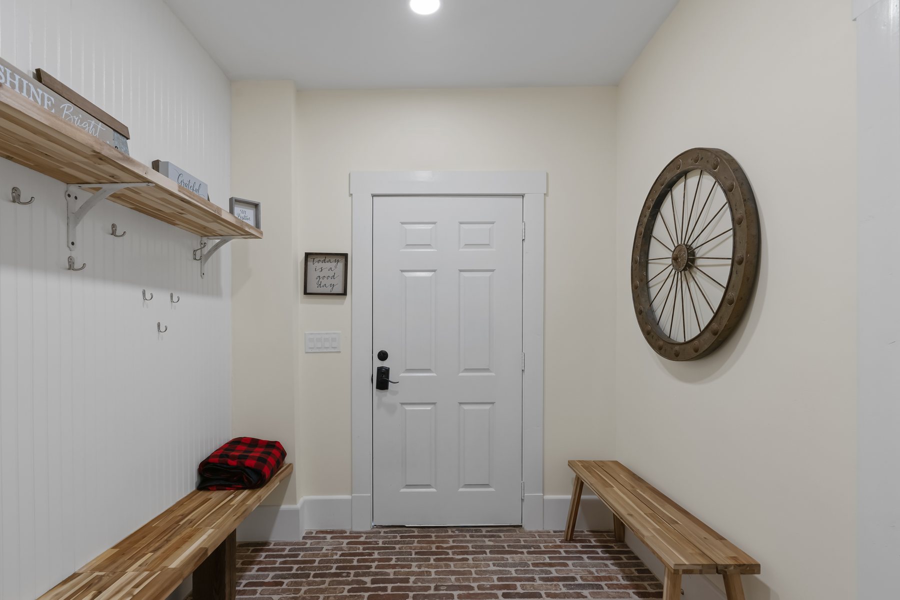 Mud room with bench seating, open shelving and a door to the rear deck.
